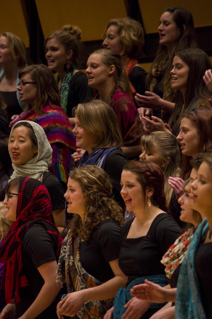 The Goshen College Women’s World Music Choir recently celebrated their 10-year anniversary with a February concert.  During performances, members wear vibrantly colored scarves and go barefoot as a way to feel connected to the earth and to women around the globe. (Photo by Hannah Sauder)